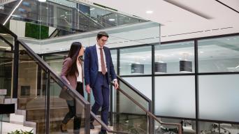 Sophia walking downstairs with businessman