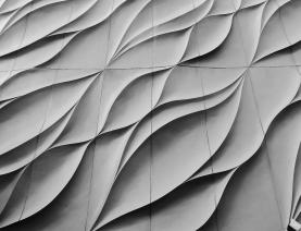 Architectural facade with wavy concrete panels in flowing design