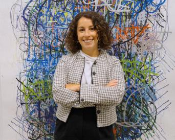 Taylor Denara infront of artwork in New York office